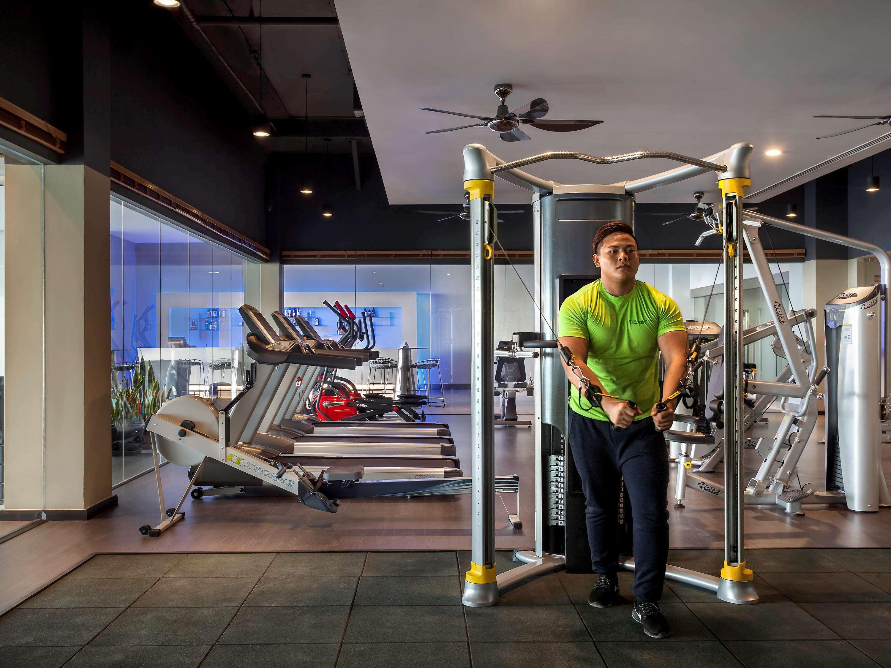 Pullman Miri Waterfront Hotel Exterior photo A man doing dips on a parallel bar